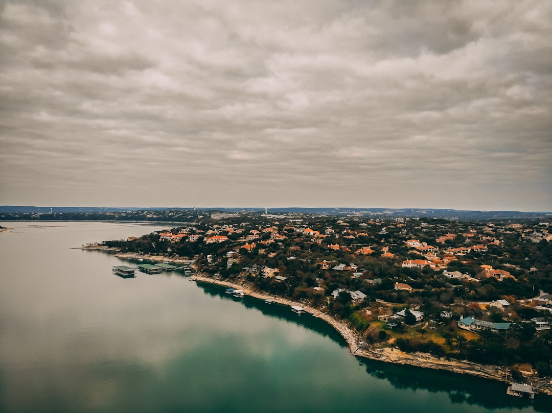 Aerial view of Austin Texas neighborhood with buildings and trees near Lake Travis