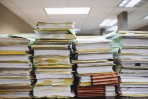 Stacks of paper documents and file folders representing mortgage paperwork