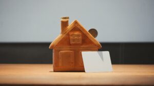 Small house with coins representing private mortgage insurance costs on a Texas mortgage