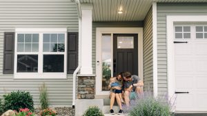 A couple sitting in front of their new Austin home after a move-up purchase