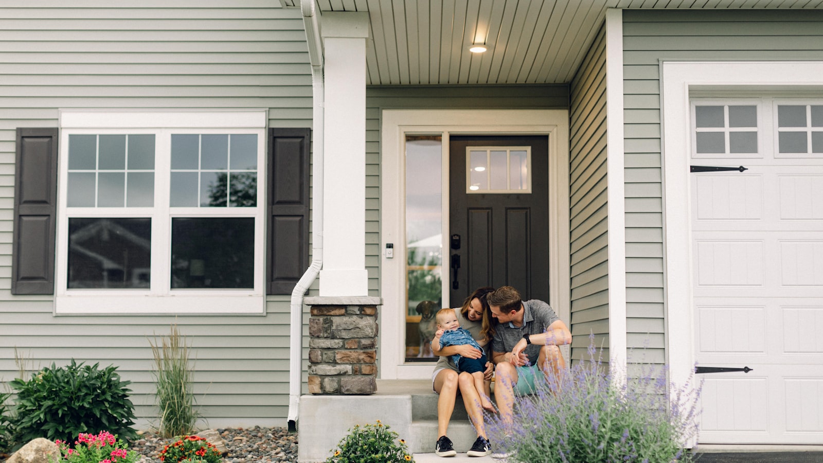 A couple sitting in front of their new Austin home after a move-up purchase