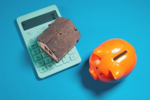 Calculator and house model illustrating mortgage discount points and buydowns in Austin