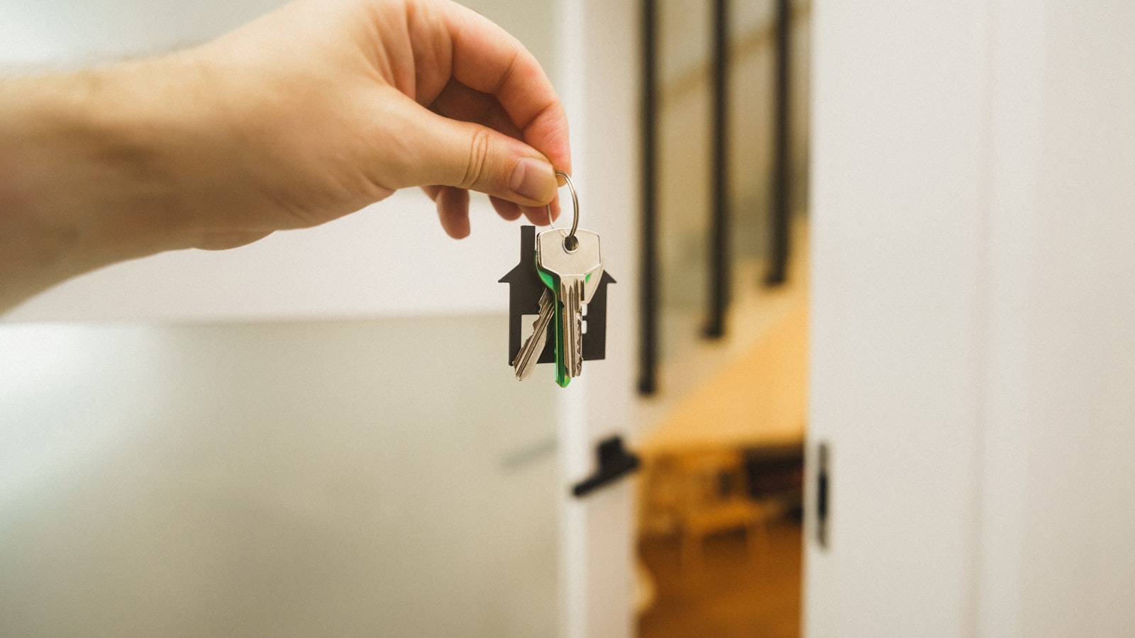 Real estate agent handing house keys to a buyer after closing on an Austin home under contract