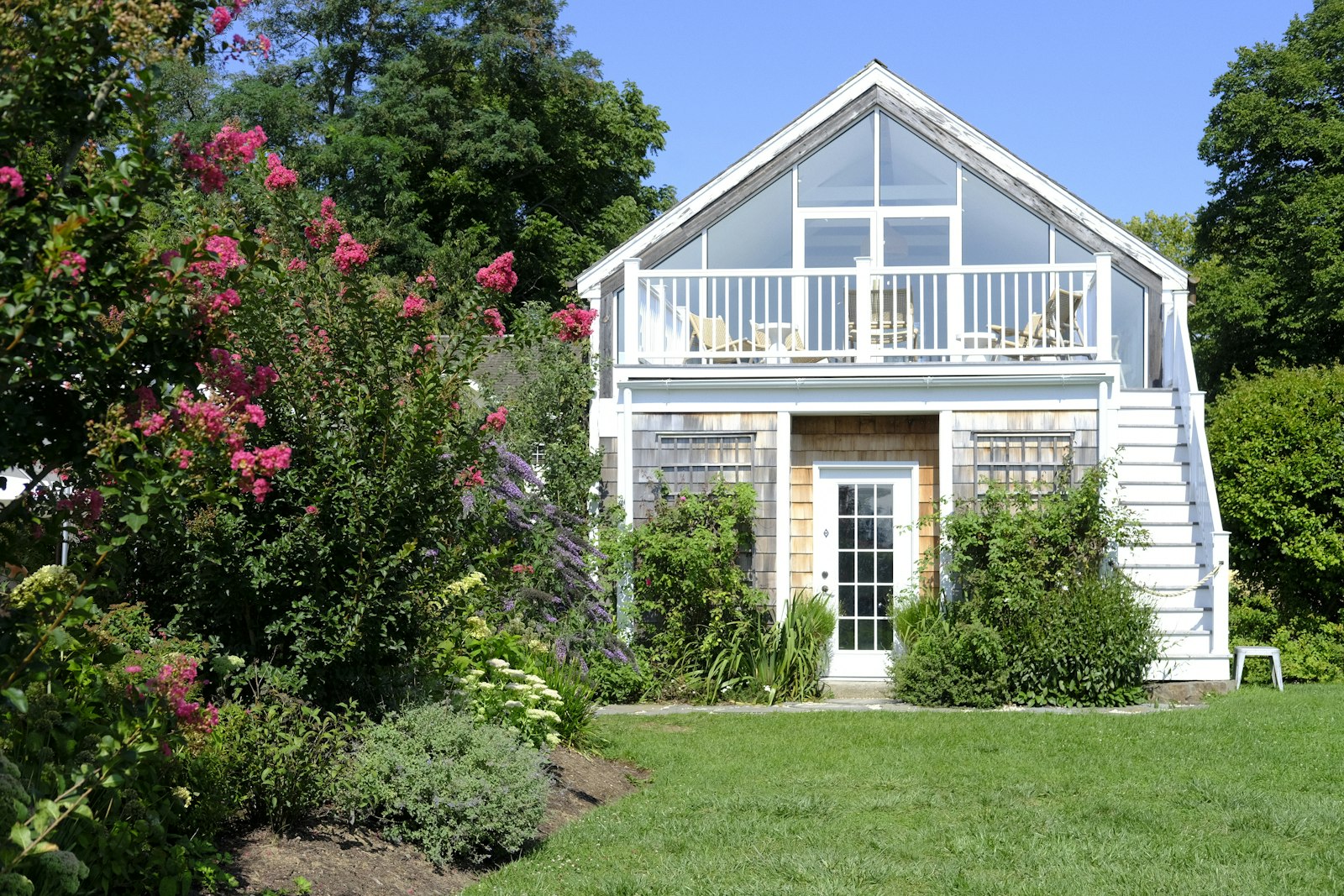 Small white cottage home with a covered porch and deck, the kind of compact home manufactured home financing and ADU rules in Austin make possible