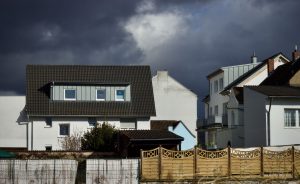 Austin area home with a shingle roof under storm clouds, illustrating a home insurance renewal increase
